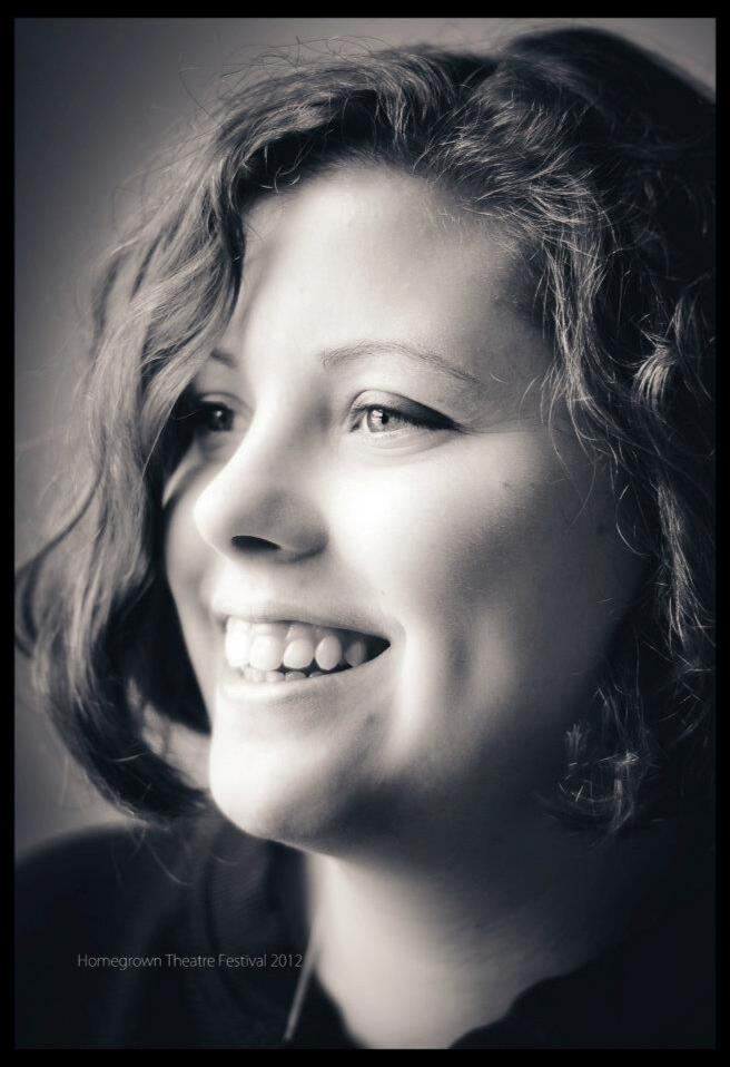 A picture of Amanda smiling and in profile facing leftward. The photo is in black and white.